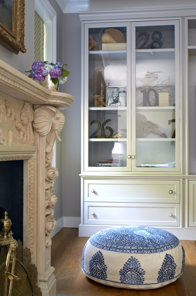 Custom glass-front built-in cabinetry beside a carved mantel, Princeton NJ