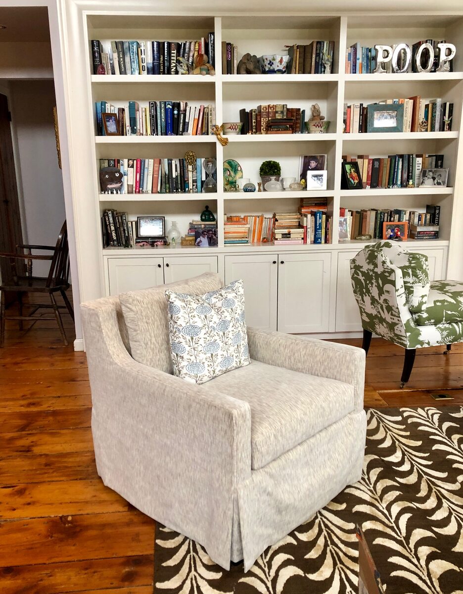 A reading chair set against floor-to-ceiling custom bookshelves and a graphic patterned rug.